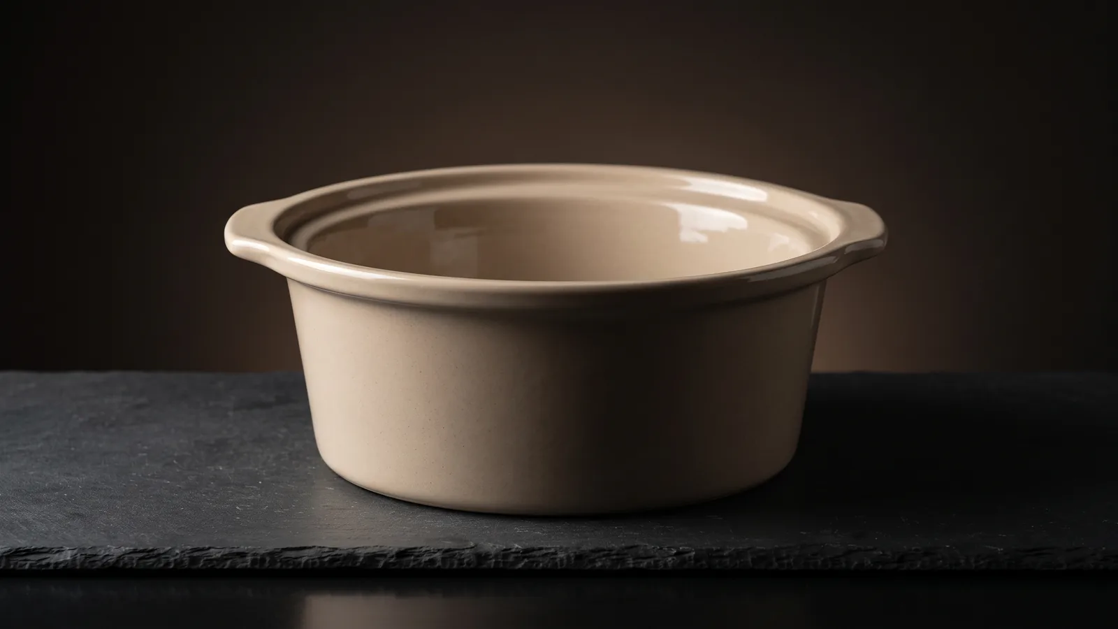 A ceramic slow cooker crock insert lifted out, its glossy glazed interior clean and empty, a safe-materials feel.